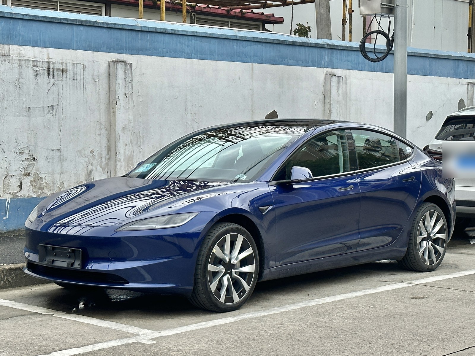 青い電気セダンを左前から見た写真(駐車場)