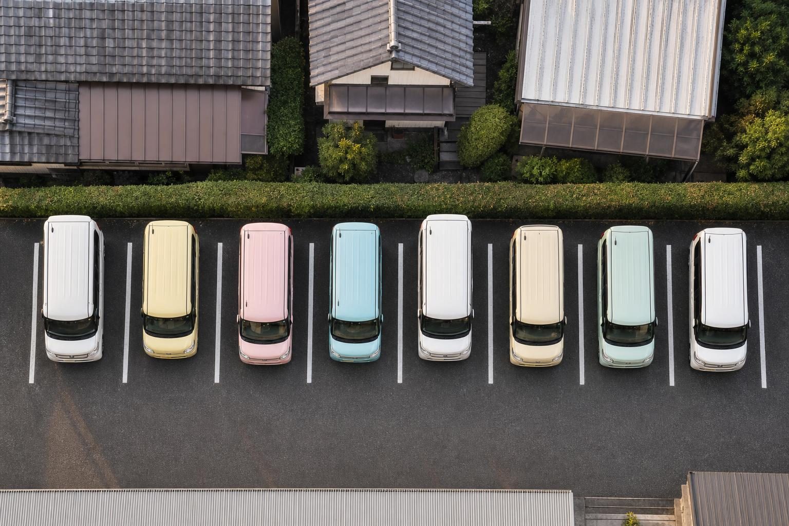住宅地の駐車場に並ぶ背の高い軽自動車を真上から見たところ
