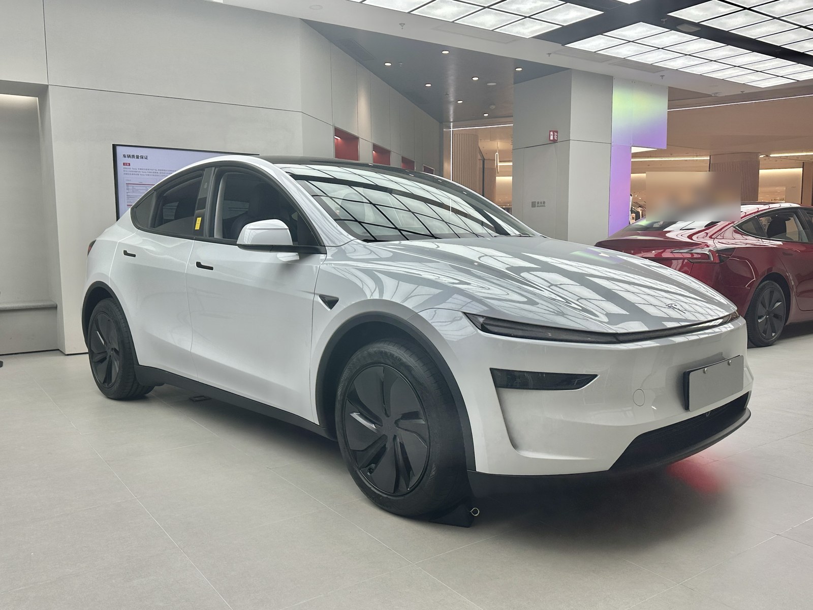 白い新型SUVタイプの電気自動車を右前から見た写真(店内展示)